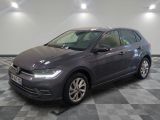Une Volkswagen Golf grise est garée dans une pièce au sol carrelé en damier.