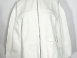 une veste blanche posée sur un mannequin, devant un fond blanc