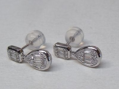 paire de boucles d'oreilles en forme d'arc ornées de diamants, sur fond blanc