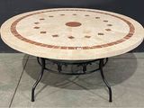 une table ronde avec un plateau en carrelage posée sur un sol en béton