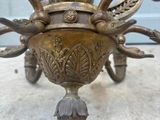 an antique brass chandelier with a bird on top of it