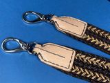 two brown and black braided lanyards on a blue surface