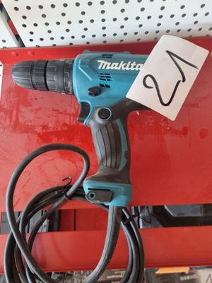 a corded drill sitting on top of a red box