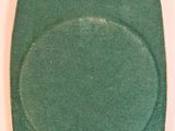 a green bag with a ring on it sitting on a table