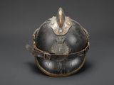 an old helmet with a metal decoration on the top of it