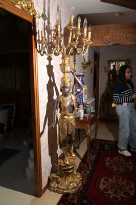 une femme debout dans une pièce où se trouve un lustre