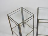 pair of metal and glass side tables on a white background