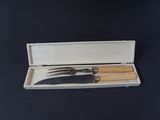 a knife and a fork in a case on a table