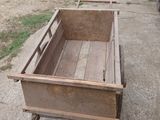 une vieille charrette en bois posée par terre à l'extérieur