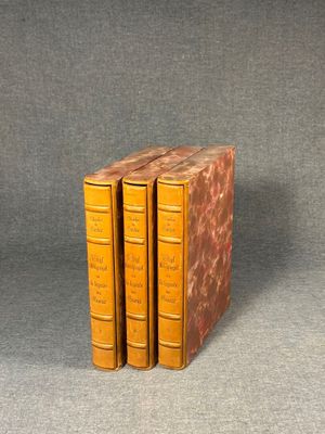 three books sitting on top of each other on a gray surface