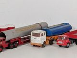 several toy trucks are lined up in a row on a white surface