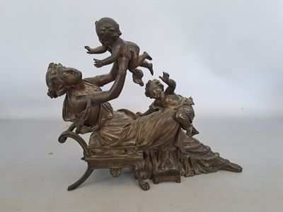 figurine antique en bronze représentant une femme allongée sur un lit avec des enfants