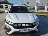 un SUV Volkswagen blanc garé devant un immeuble