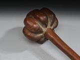 a wooden stick with a flower on it on a white surface