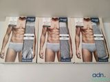 three boxes of men ' s underwear sitting on top of a table