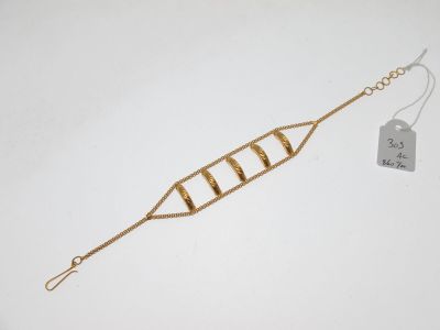 un bracelet en or auquel est attachée une longue chaîne