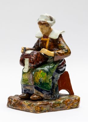 une photo d'une figurine représentant une femme assise sur un banc