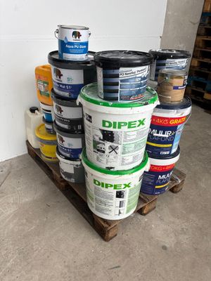 several buckets of paint are stacked on a pallet in a warehouse