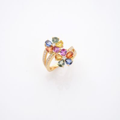 un gros plan d'une bague ornée de pierres multicolores sur un fond blanc