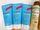 three sunscreens and a bottle of lotion on a table