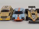 three toy cars sitting next to each other on a white surface