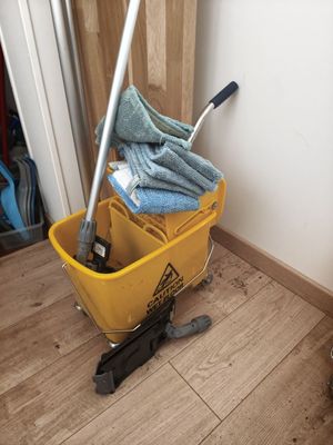a mop and a bucket on the floor next to a door