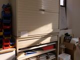 une armoire au milieu d'une pièce, avec de nombreuses boîtes par terre