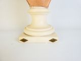 a white vase with a wooden top on a white table