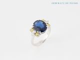 a close up of a ring with a blue stone on it