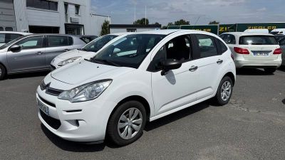 une petite voiture blanche garée dans un parking