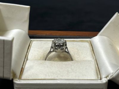 une bague en diamant dans une boîte blanche sur fond noir