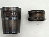 a silver cup sitting next to a silver cup on a table