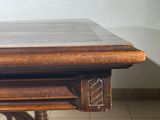 a wooden table with a marble top on a tiled floor