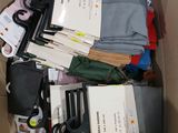 une boîte remplie de vêtements, avec une paire de ciseaux à l'intérieur