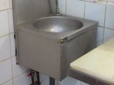 un lavabo situé dans un coin d'une salle de bains dotée d'une fenêtre