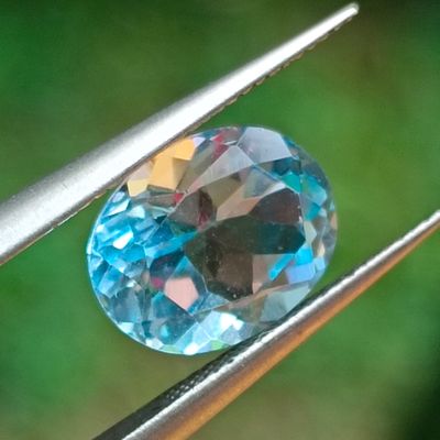 a close up of a blue diamond being held by a pair of pliers