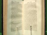 two wine glasses sitting on top of an open book