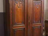 une grande armoire en bois dans le coin d'une pièce
