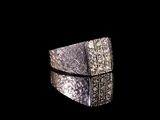 une image représentant une bague en argent sertie de diamants sur fond noir