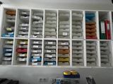a white shelf with many bins of various items in it