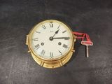 une horloge en or avec des chiffres romains et une clé