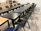 tables and chairs are lined up in a room with a tv