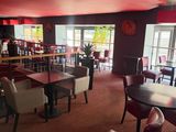 tables and chairs in a restaurant with red walls and a red ceiling