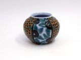 a blue and black vase with a leopard print design on it