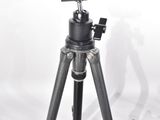a tripod with a camera and other tools on a table