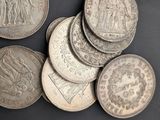 several silver coins are arranged in a circle on a black surface