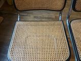 pair of black and wicker chairs with chrome legs