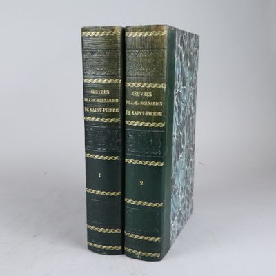 deux livres verts posés l'un sur l'autre sur une surface blanche