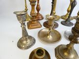 many different types of brass candles on the table