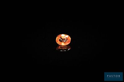 gros plan d'un diamant orange sur une surface noire